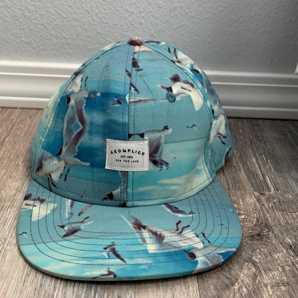 This is a flat bill hat. Brand: AKOMPLICE